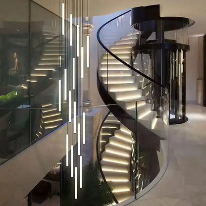 Modern black LED spiral staircase chandelier in living room with glass railing and lit steps on Tampa Home & Garden Store