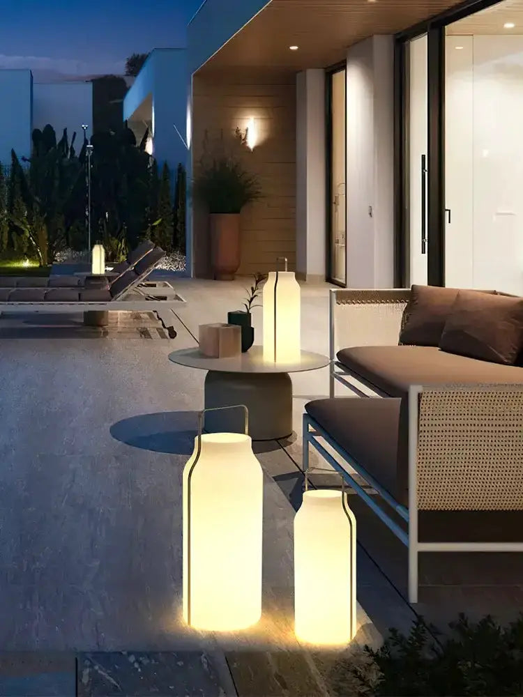 Minimalist stainless steel LED garden lanterns in a trio with warm white glow on a modern patio on Tampa Home & Garden Store