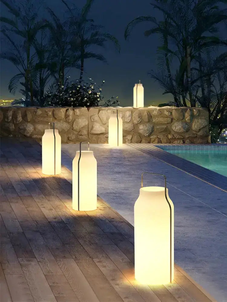 Minimalist stainless steel LED lawn lanterns with warm glow, five along a pool deck Decorbites on Tampa Home & Garden Store
