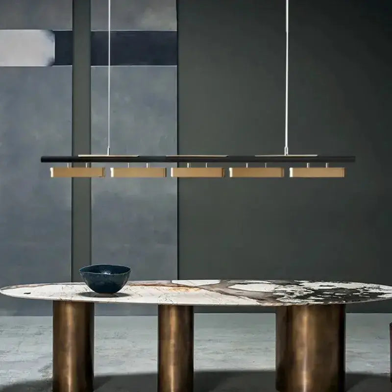 Chandelier: modern minimalist strip LED pendant in black with gold accents over a marble table on Tampa Home & Garden Store