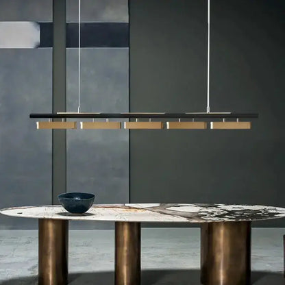 Chandelier: modern minimalist strip LED pendant in black with gold accents over a marble table on Tampa Home & Garden Store