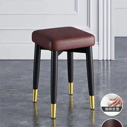 Decorbites modern low dining stool with brown upholstered seat and black legs with gold tips on Tampa Home & Garden Store