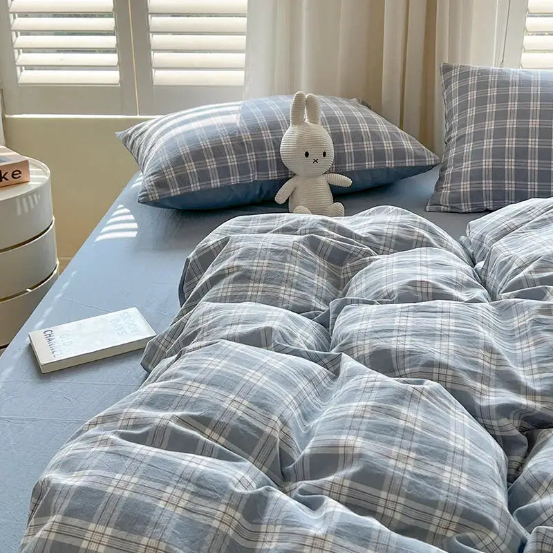 Blue plaid duvet set with two matching pillowcases on a bed, paired with a plush bunny and book on Tampa Home & Garden Store