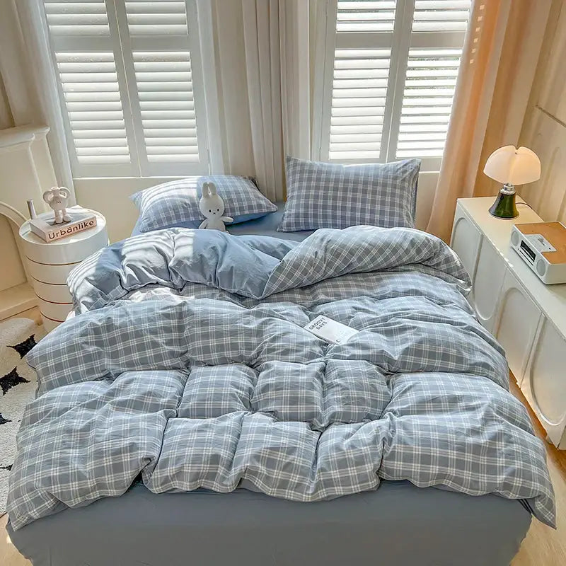Blue plaid duvet set by Decorbites on bed with two matching plaid pillows on Tampa Home & Garden Store