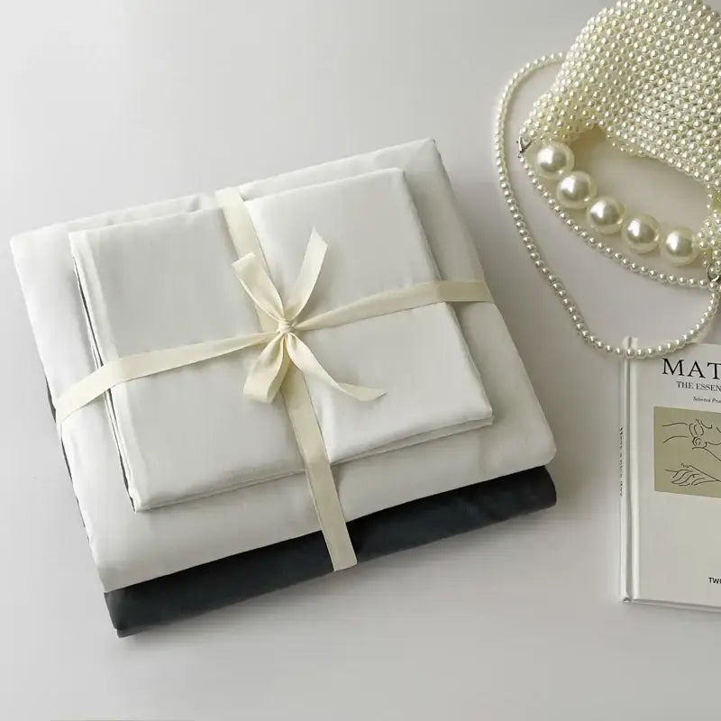 Decorbites duvet cover set in white and dark gray, folded with cream ribbon on Tampa Home & Garden Store