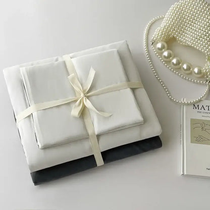 Decorbites duvet cover set in white and dark gray, folded with cream ribbon on Tampa Home & Garden Store