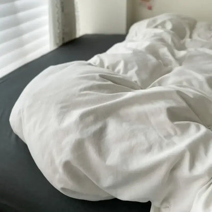 Decorbites duvet cover set in white and dark gray on bed on Tampa Home & Garden Store