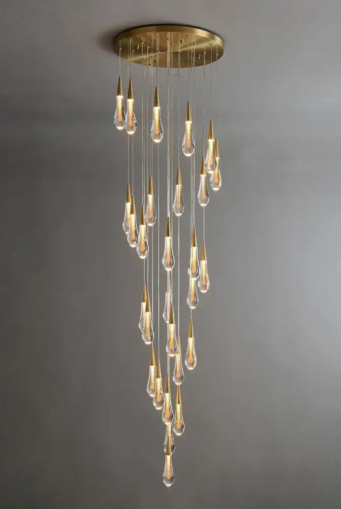 Gold teardrop chandelier with clear glass drops and gold tips, cascading from round ceiling plate on Tampa Home & Garden Store