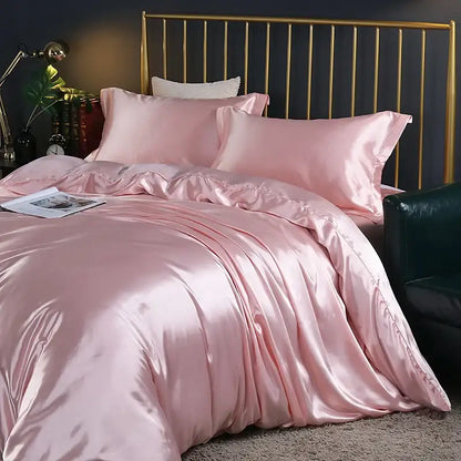 Duvet cover set by Decorbites in pink satin on a bed with matching pillows and brass headboard on Tampa Home & Garden Store