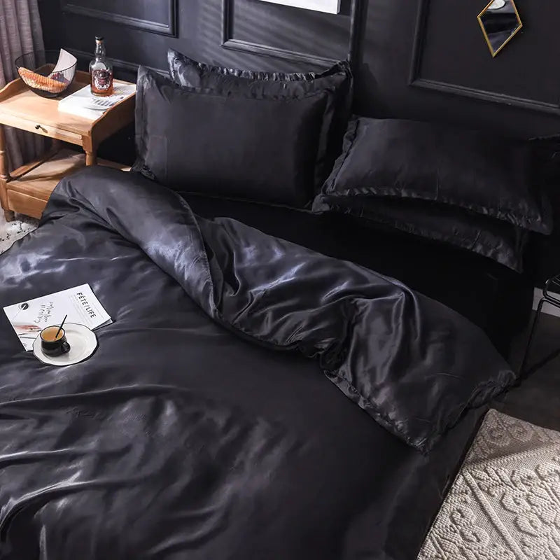 Black silk duvet cover set with satin sheen and matching pillowcases on a bed in a moody bedroom on Tampa Home & Garden Store