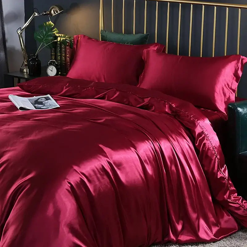 Pink satin bedding set with two red pillowcases and a green accent pillow on Tampa Home & Garden Store