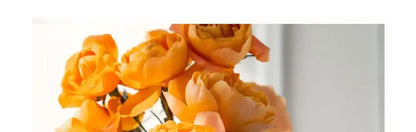 Silver stainless steel vase with vibrant orange flowers by Decorbites on Tampa Home & Garden Store