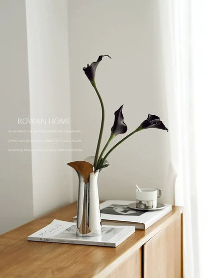 Silver stainless steel vase by Decorbites with 3 dark purple calla lilies on a wooden console on Tampa Home & Garden Store