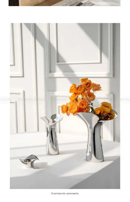 Silver stainless steel vase set by Decorbites; two vases, one filled with orange roses on Tampa Home & Garden Store