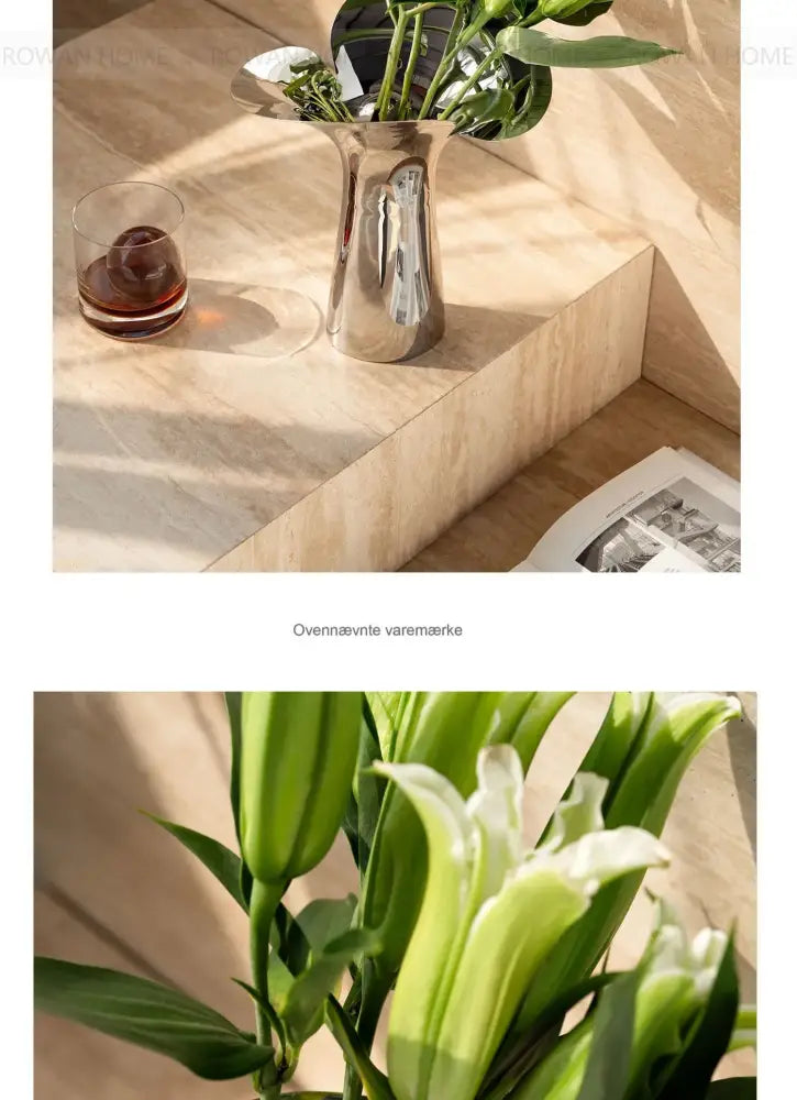 Silver stainless steel vase by Decorbites with green stems on a beige stone surface on Tampa Home & Garden Store