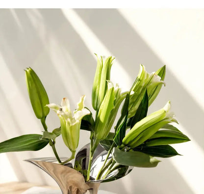 Silver stainless steel vase with green-white lily bouquet and lush leaves on Tampa Home & Garden Store