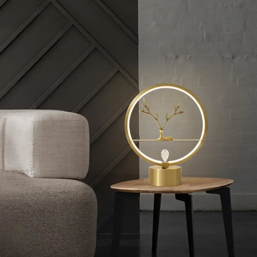 Gold Deer Table Lamp by Decorbites with LED ring and brass deer silhouette on a wooden table on Tampa Home & Garden Store