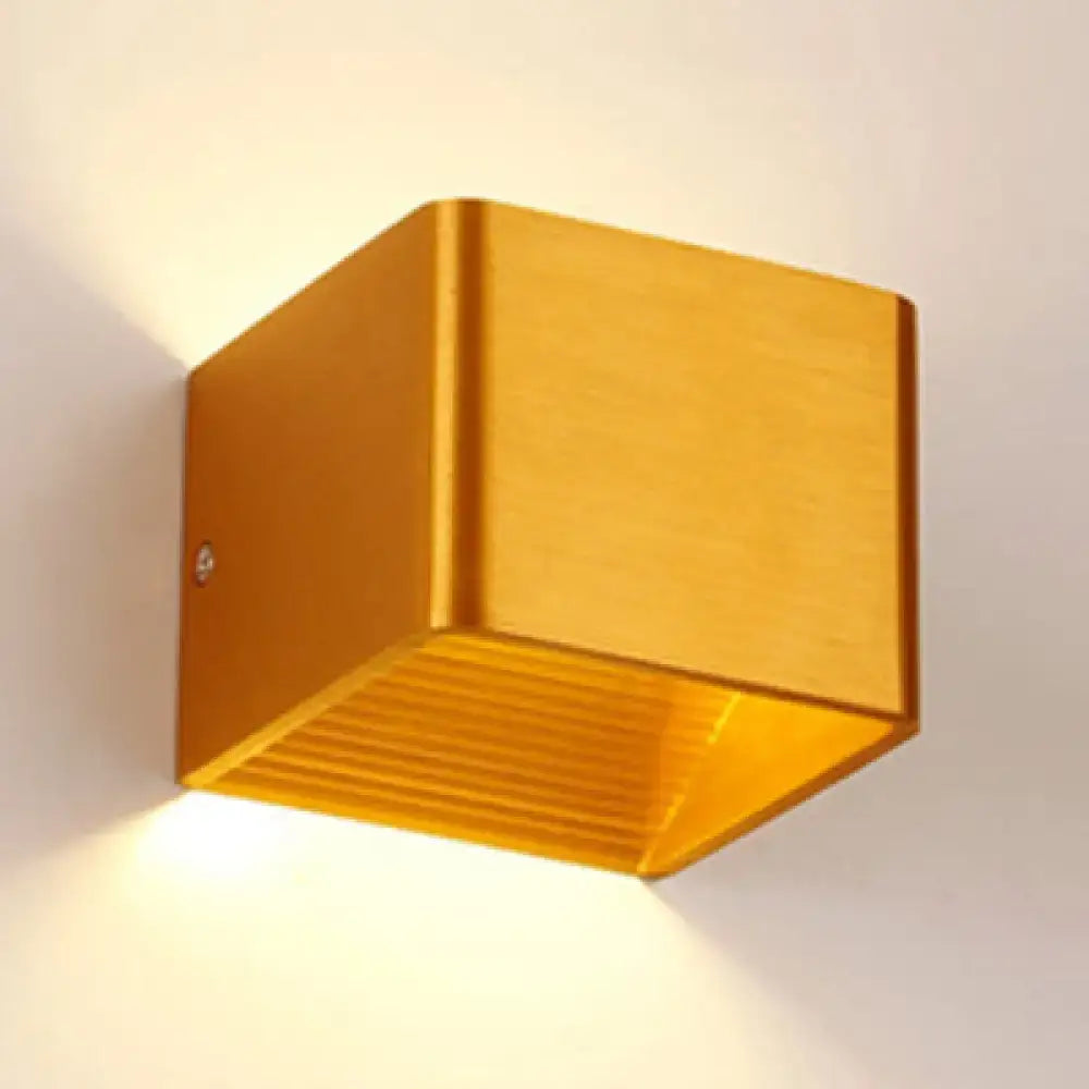 Black Cube Wall Sconce in gold brass metal finish with warm light glow on wall on Tampa Home & Garden Store