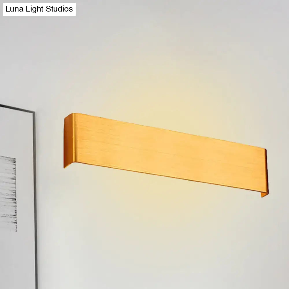 Wooden horizontal wall lamp sconce emitting warm light on a pale wall on Tampa Home & Garden Store