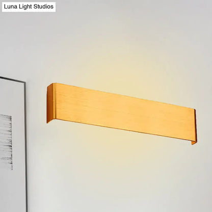Wooden horizontal wall lamp sconce emitting warm light on a pale wall on Tampa Home & Garden Store