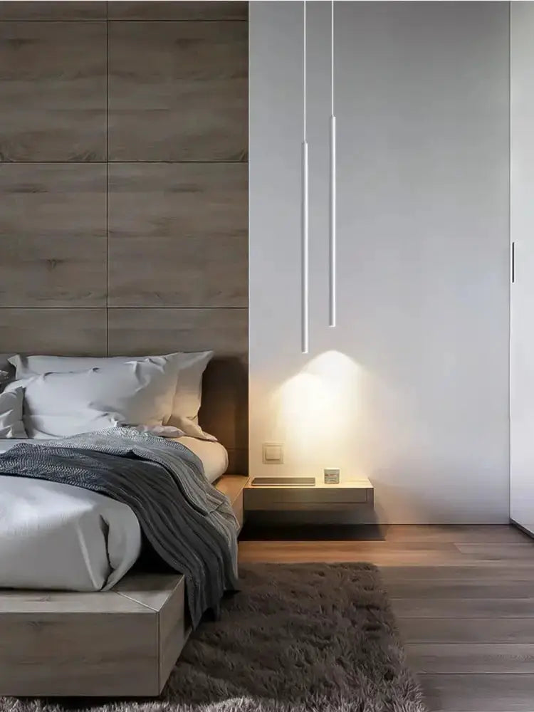 LED pendant lights two slim white vertical fixtures above a bedside table in a modern bedroom on Tampa Home & Garden Store