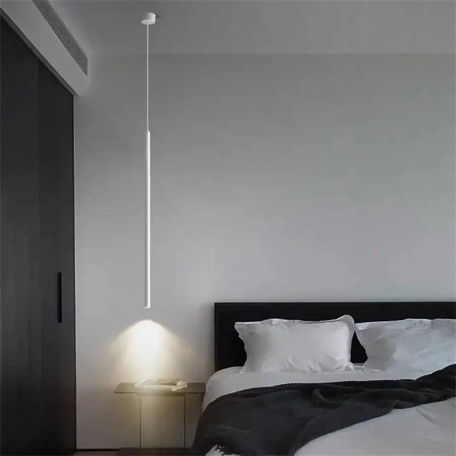 Slim white LED pendant light hanging over bedside table in a modern bedroom Decorbites pendant lighting on Tampa Home & Garden Store