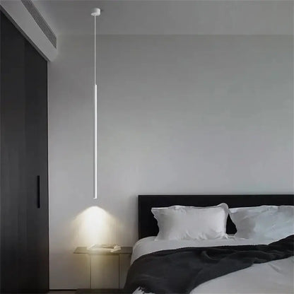 Slim white LED pendant light hanging over bedside table in a modern bedroom Decorbites pendant lighting on Tampa Home & Garden Store