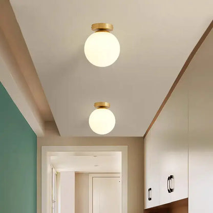 Brass Ball Ceiling Lights pair with frosted glass globes in a hallway on Tampa Home & Garden Store
