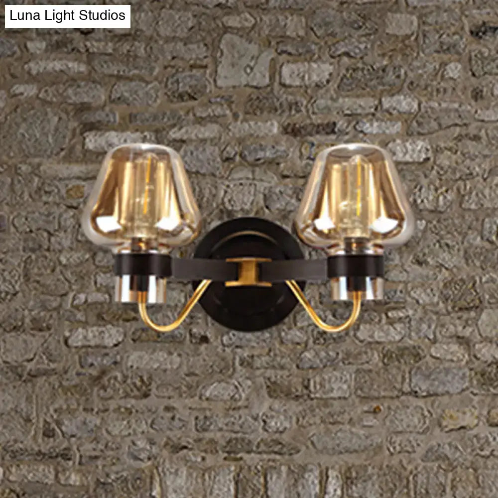 Amber glass mushroom sconce with dual lights and black wall mount, gold-tone arms on wall on Tampa Home & Garden Store