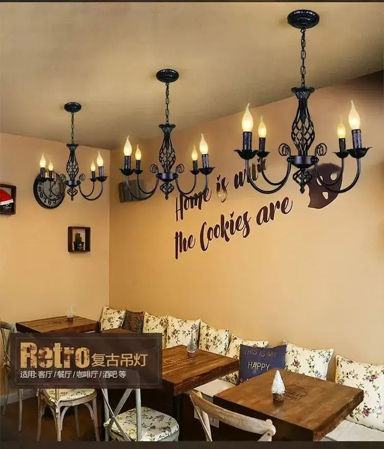Black Iron Scroll Chandeliers by Decorbites in a cafe with beige walls and wooden tables on Tampa Home & Garden Store