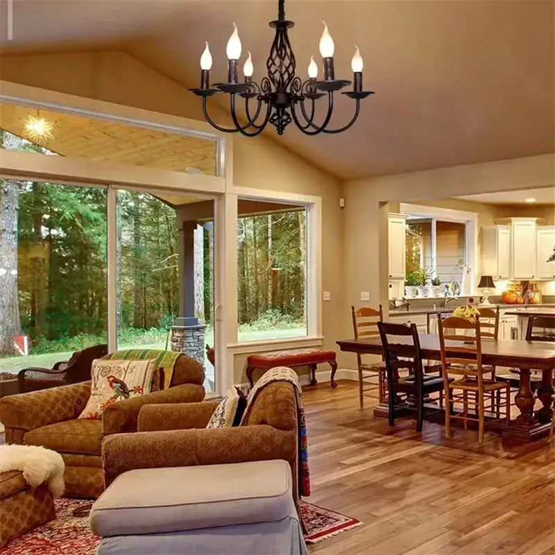 Black iron scroll chandelier with eight candle bulbs over a cozy open living-dining area on Tampa Home & Garden Store