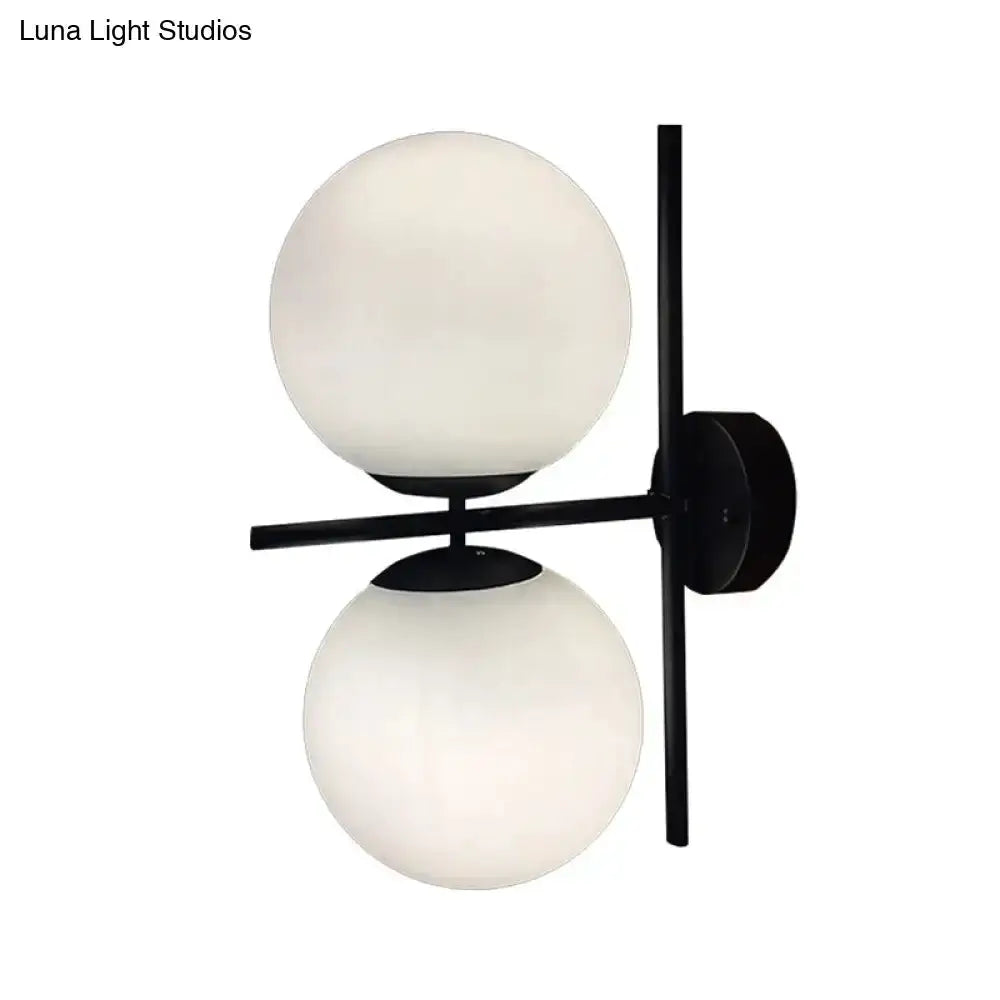 Double globe wall sconce with black metal frame and two white frosted glass spheres on Tampa Home & Garden Store