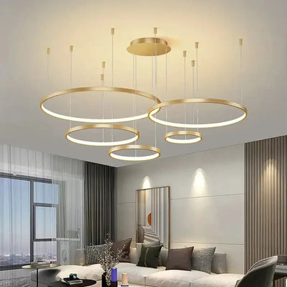 Modern black & gold pendant chandelier with dimmable circular LED rings in a living room on Tampa Home & Garden Store