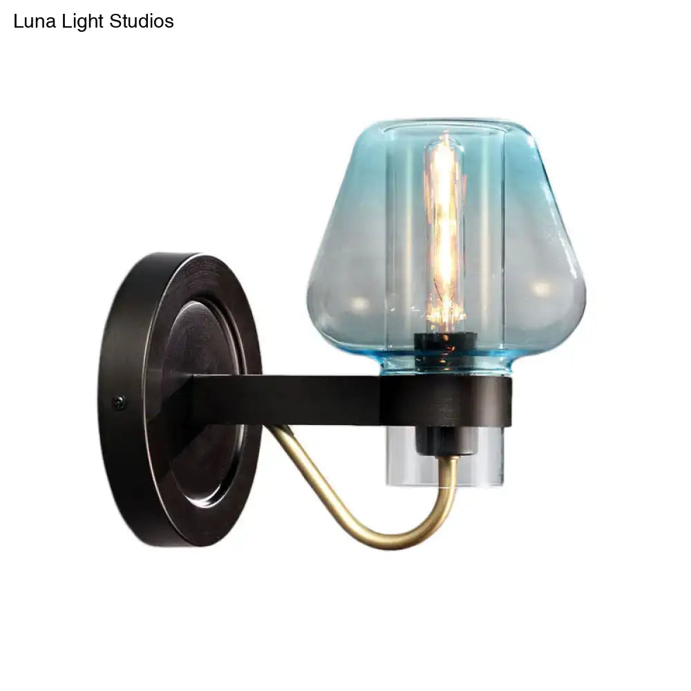 Blue glass tapered wall sconce with black metal mount and brass curved arm, Edison bulb on Tampa Home & Garden Store