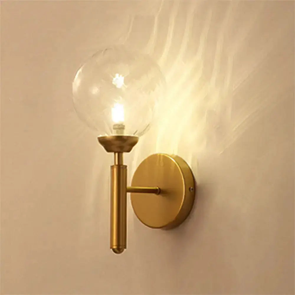 Modern brass glass sphere wall lamp with clear globe and gold wall mount on Tampa Home & Garden Store