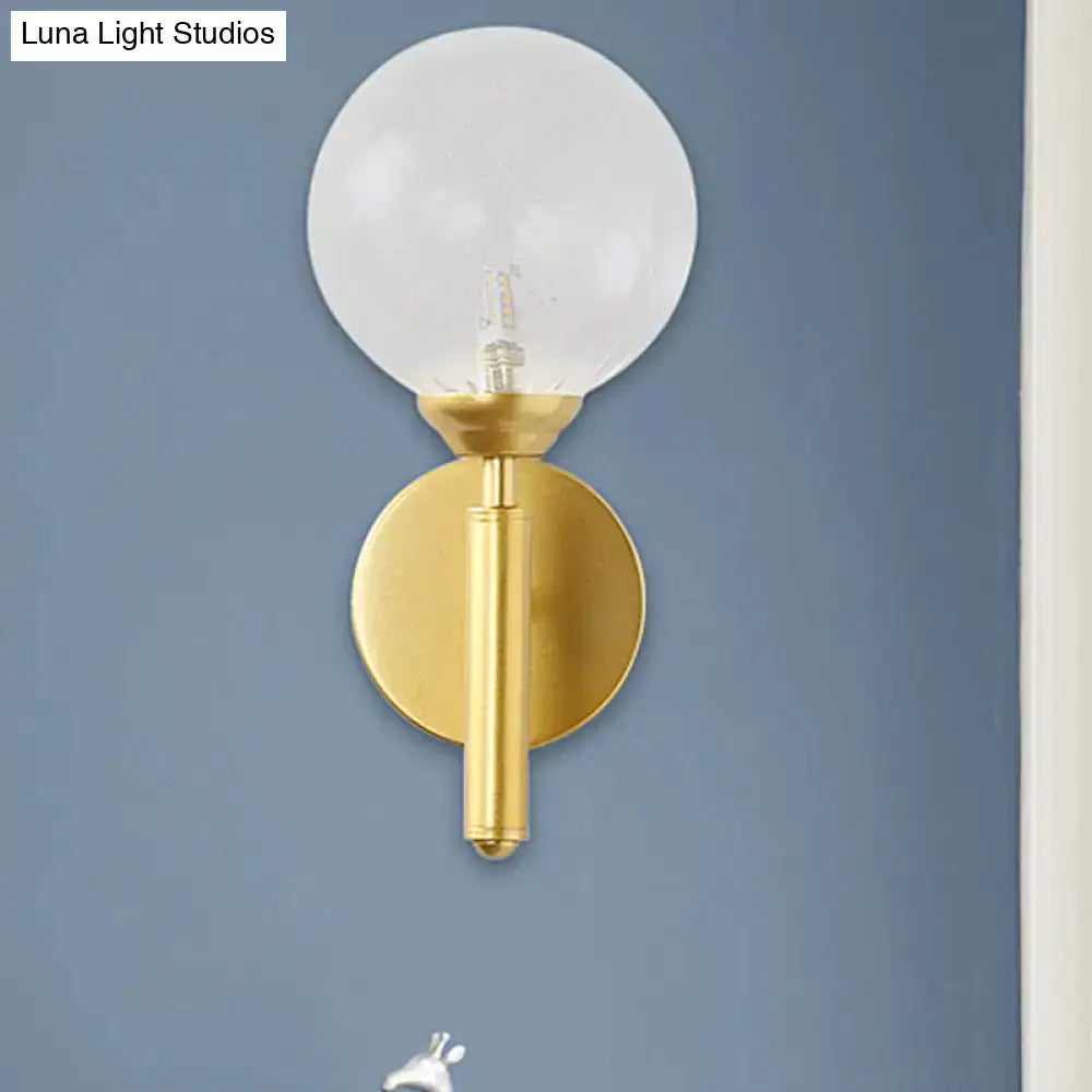 Brass glass sphere wall lamp with clear globe bulb and round backplate on Tampa Home & Garden Store