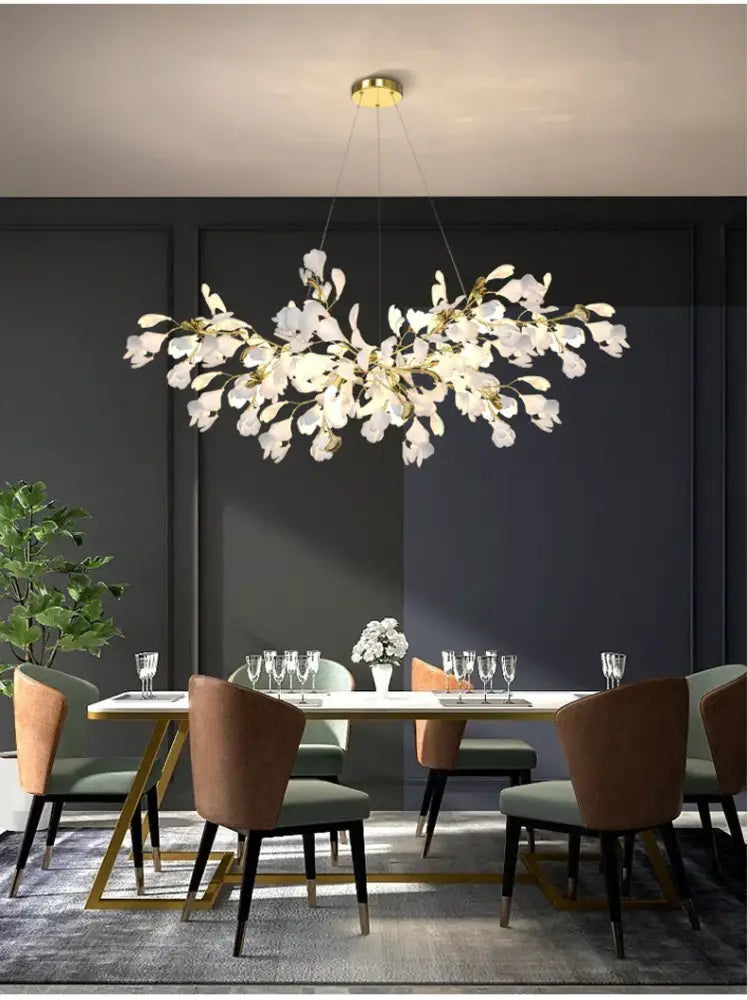Gold Ginkgo LED Chandelier by Decorbites with leaf motifs over a dining table on Tampa Home & Garden Store