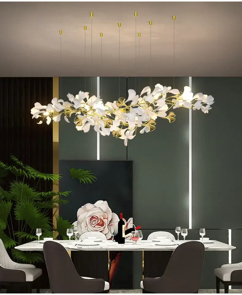 Decorbites Gold Ginkgo LED Chandelier with white leaf accents and gold branches over dining on Tampa Home & Garden Store