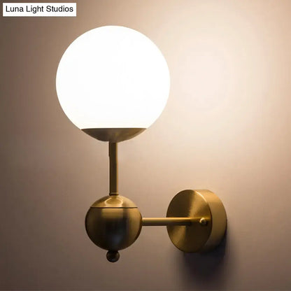Brass globe bathroom sconce with white glass shade by Decorbites on Tampa Home & Garden Store