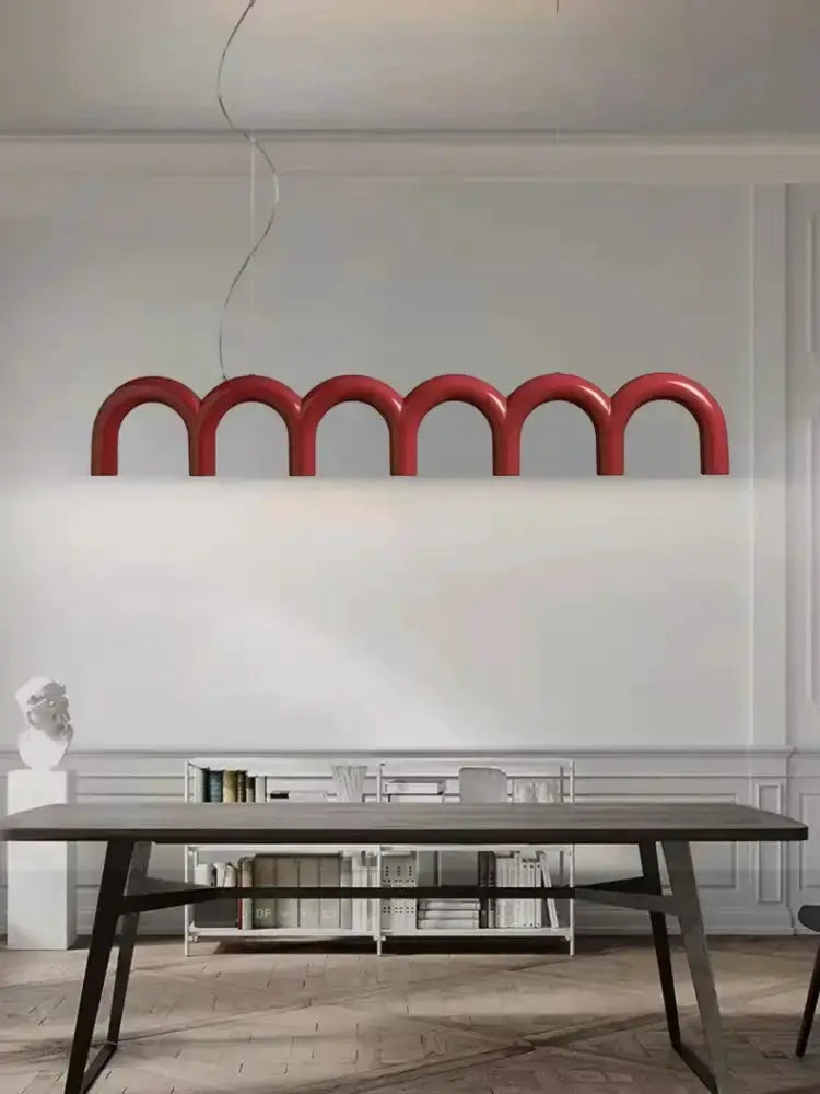 Chandelier: red LED arch pendant light with curved loops over dining table in modern decor on Tampa Home & Garden Store
