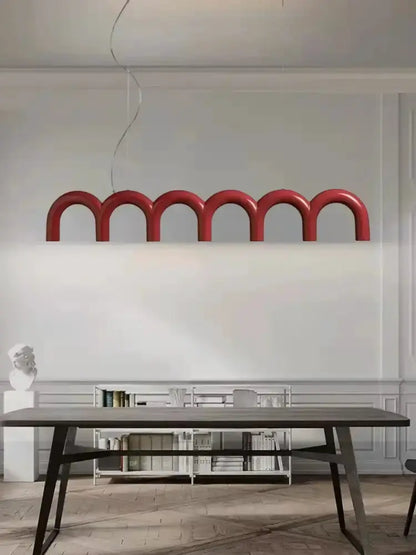 Chandelier: red LED arch pendant light with curved loops over dining table in modern decor on Tampa Home & Garden Store