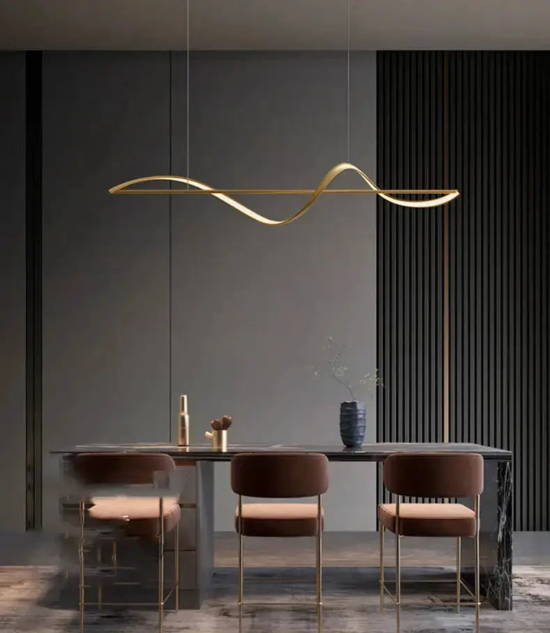 Chandelier gold curved LED pendant over dark dining table with 3 brown velvet chairs Decorbites on Tampa Home & Garden Store