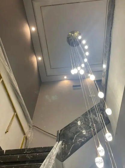 Decorbites modern gold LED crystal chandelier cascading pendant above marble stairs on Tampa Home & Garden Store