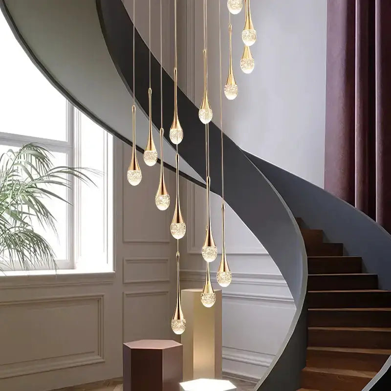 Modern gold LED crystal chandelier cascading pendant drops over a curved staircase dining area on Tampa Home & Garden Store