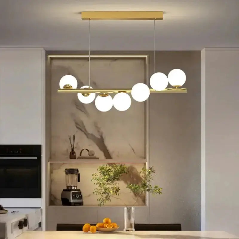 Modern gold linear LED glass chandelier pendant light Decorbites with globe bulbs over island on Tampa Home & Garden Store