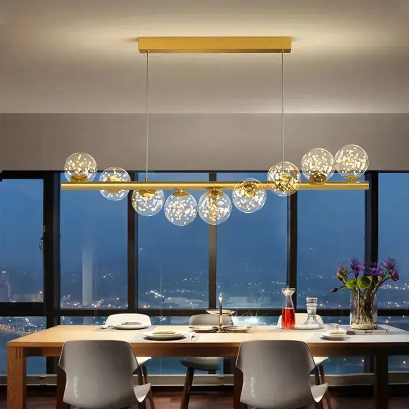 Decorbites modern gold linear LED glass chandelier with globe bulbs over a dining table on Tampa Home & Garden Store