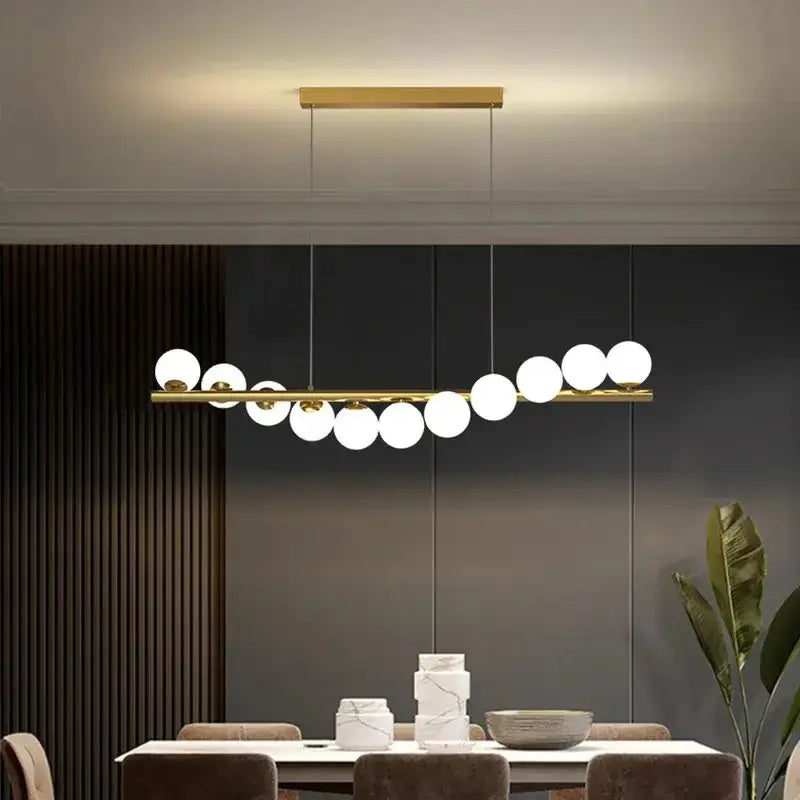 Modern gold linear LED glass chandelier with white globe pendants over dining table Decorbites on Tampa Home & Garden Store