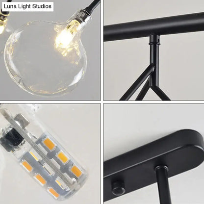 Chandelier lighting fixture with clear glass bulb, black metal frame and round canopy LED module on Tampa Home & Garden Store
