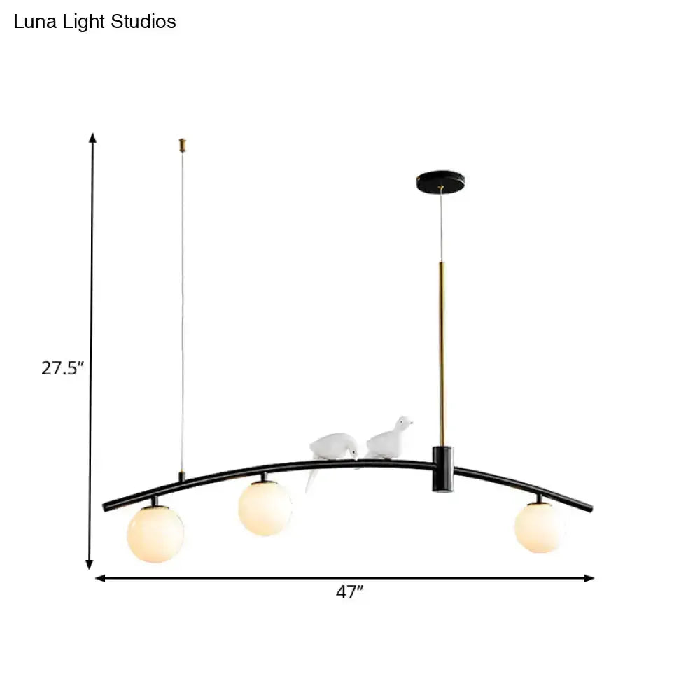Pendant light in black and brass with 3 milk glass globes and bird accents on arc on Tampa Home & Garden Store