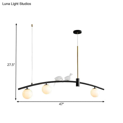 Pendant light in black and brass with 3 milk glass globes and bird accents on arc on Tampa Home & Garden Store